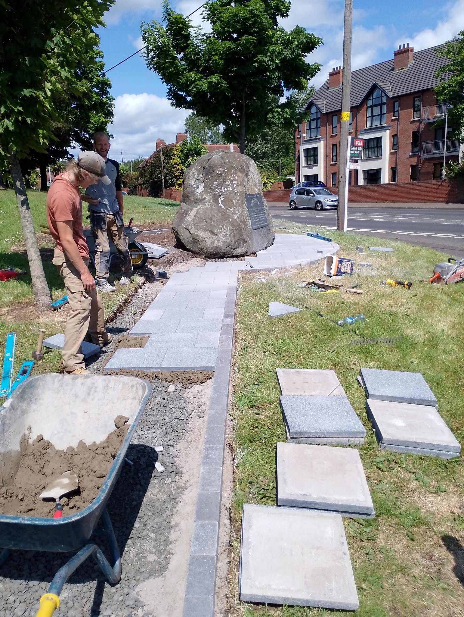 Workers installing paving stones around the U.S. Ranger memorial in Carrickfergus during restoration work.